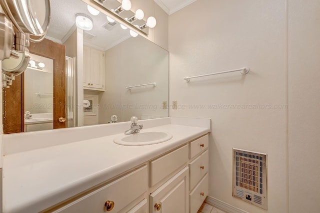 bathroom featuring ornamental molding, heating unit, vanity, and a textured ceiling