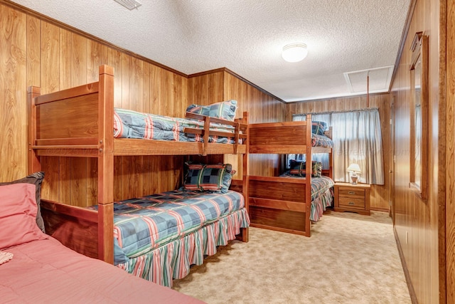 bedroom featuring light carpet, crown molding, a textured ceiling, and wood walls