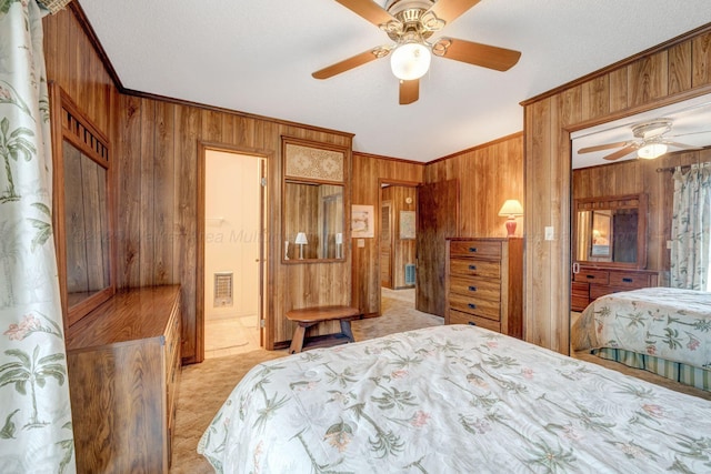 carpeted bedroom featuring ornamental molding, ceiling fan, and wood walls