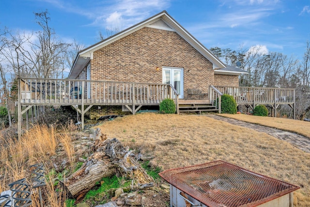 rear view of property featuring a wooden deck and a yard