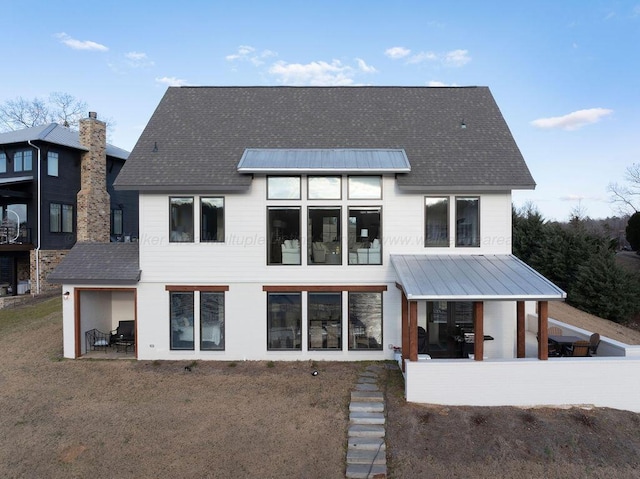 rear view of house with a patio and a yard