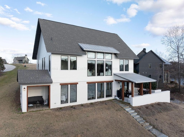 back of property featuring a patio area and a lawn