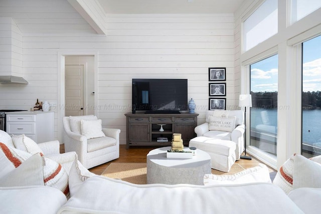 living room featuring beamed ceiling and light wood-type flooring