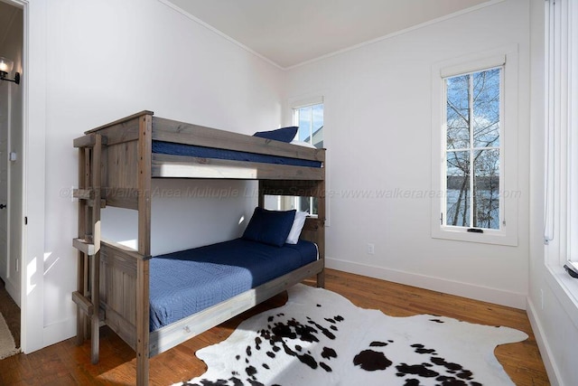 bedroom with ornamental molding and dark hardwood / wood-style flooring