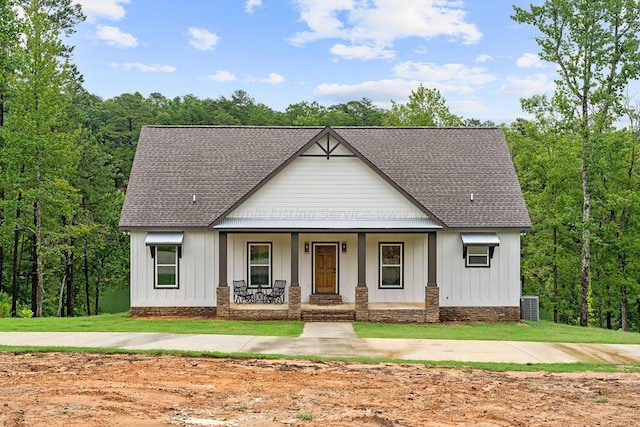 modern inspired farmhouse with central air condition unit, covered porch, and a front yard