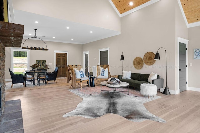 living room featuring wooden ceiling, high vaulted ceiling, crown molding, and light hardwood / wood-style flooring