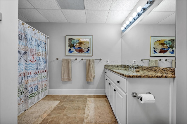 bathroom featuring vanity and a drop ceiling