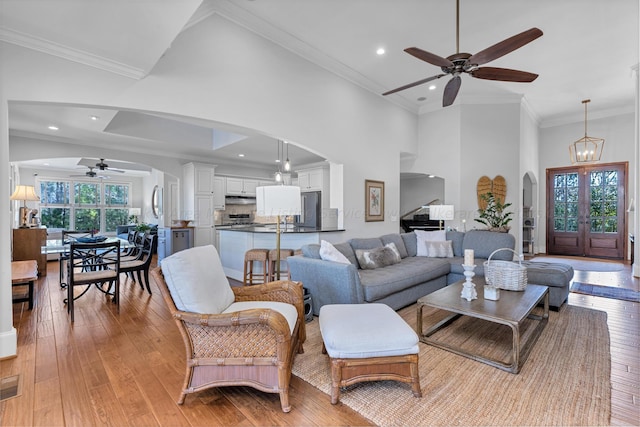 living room with ornamental molding, plenty of natural light, light hardwood / wood-style floors, and a high ceiling