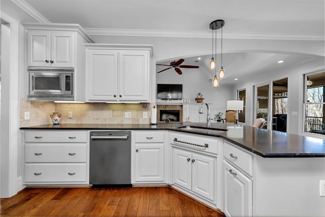 kitchen with pendant lighting, sink, crown molding, appliances with stainless steel finishes, and white cabinets