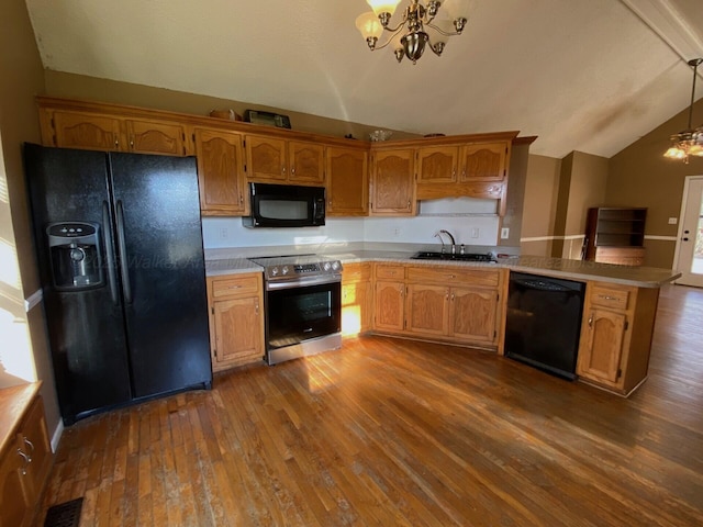 kitchen with vaulted ceiling, a notable chandelier, black appliances, and a sink