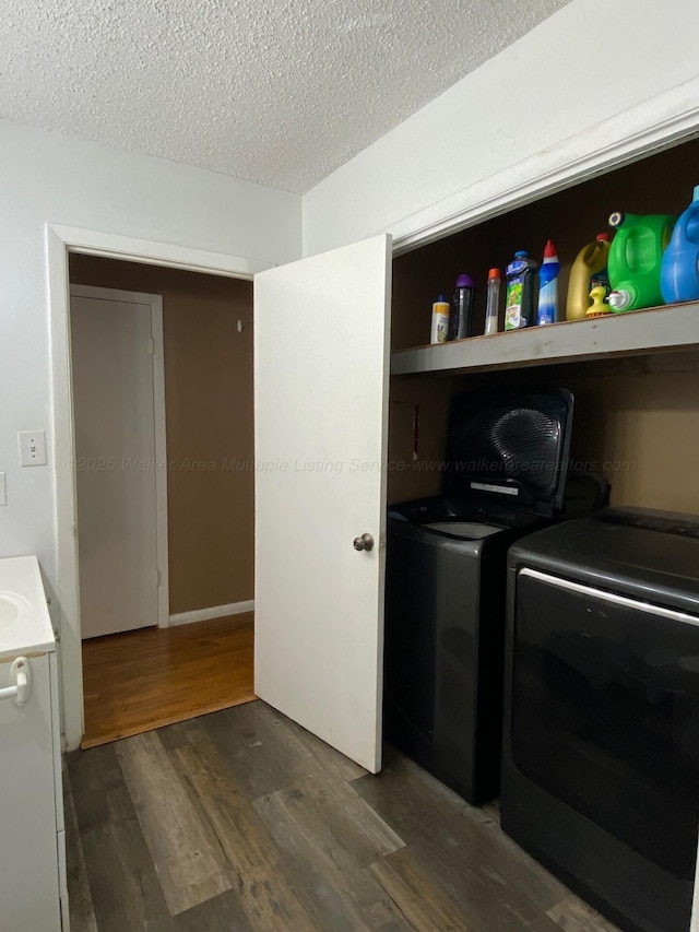 laundry area featuring dark wood finished floors, laundry area, washer and dryer, and a textured ceiling