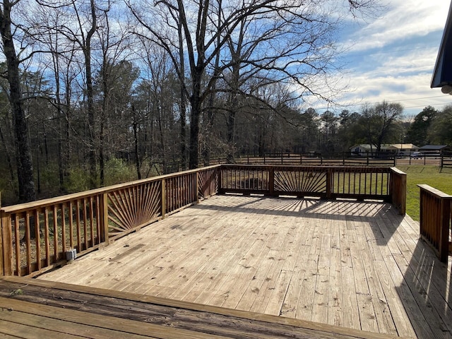 wooden terrace featuring a lawn and fence