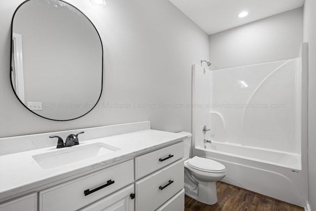 full bathroom with vanity, hardwood / wood-style floors, bathtub / shower combination, and toilet