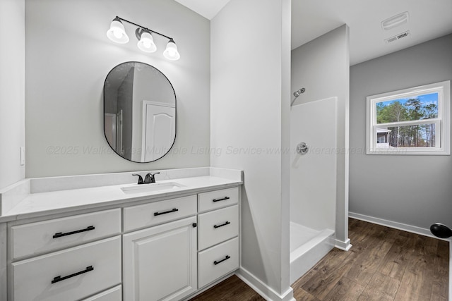 bathroom with vanity, hardwood / wood-style floors, and walk in shower