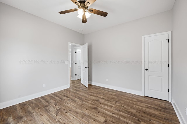 empty room featuring dark wood-type flooring and ceiling fan