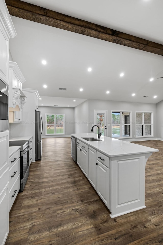 kitchen with dark wood-type flooring, sink, an island with sink, stainless steel appliances, and white cabinets