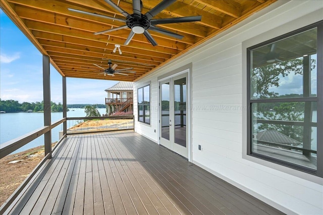 deck with ceiling fan and a water view