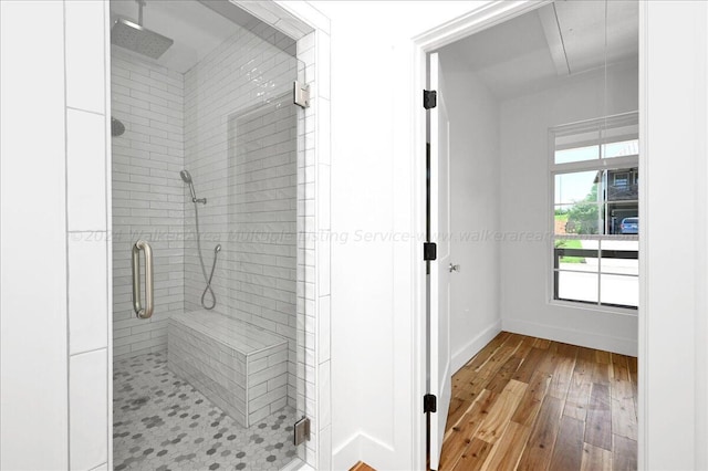 bathroom featuring hardwood / wood-style flooring and a shower with shower door