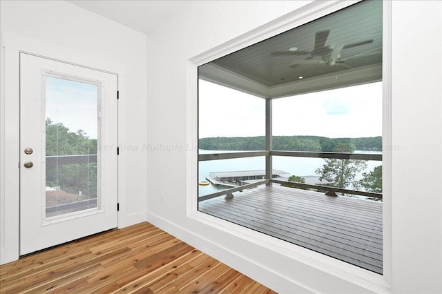 doorway to outside with wood-type flooring, a water view, and ceiling fan