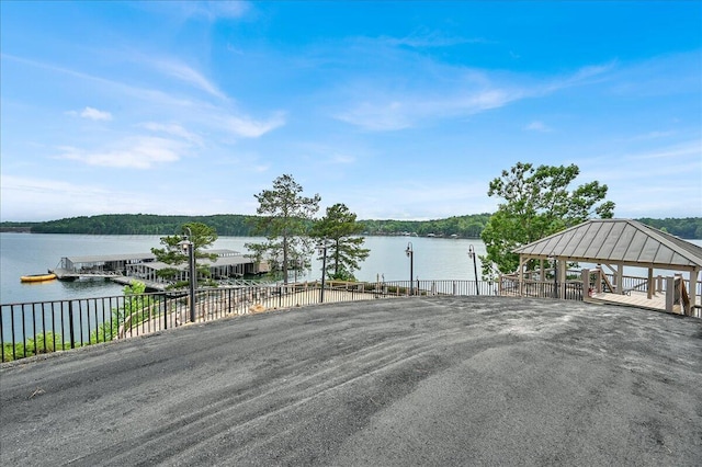 wooden terrace featuring a gazebo and a water view