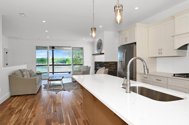 kitchen featuring pendant lighting, ceiling fan, sink, and stainless steel refrigerator with ice dispenser