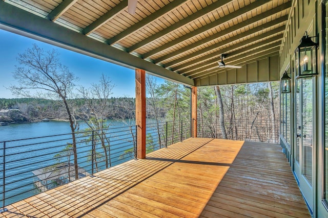 wooden deck with a water view and ceiling fan