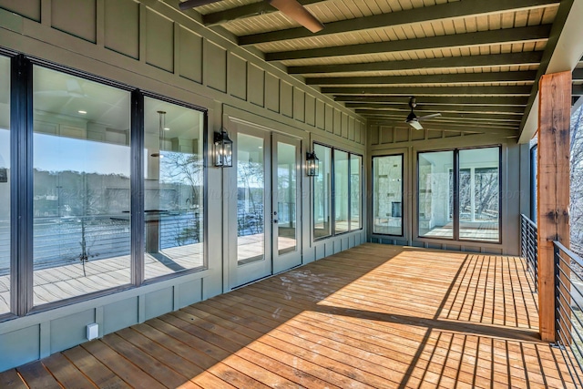 unfurnished sunroom featuring a ceiling fan, wooden ceiling, plenty of natural light, and lofted ceiling with beams