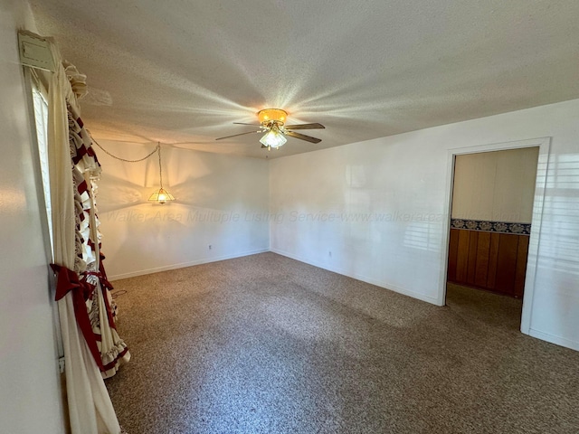 carpeted spare room featuring a textured ceiling and ceiling fan