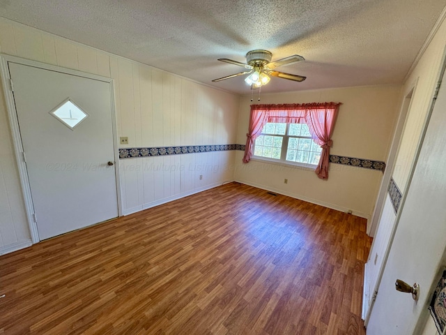 unfurnished room with hardwood / wood-style floors, ceiling fan, and a textured ceiling