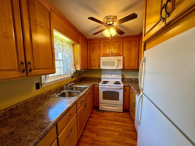 kitchen featuring white appliances, sink, dark hardwood / wood-style floors, ceiling fan, and a textured ceiling