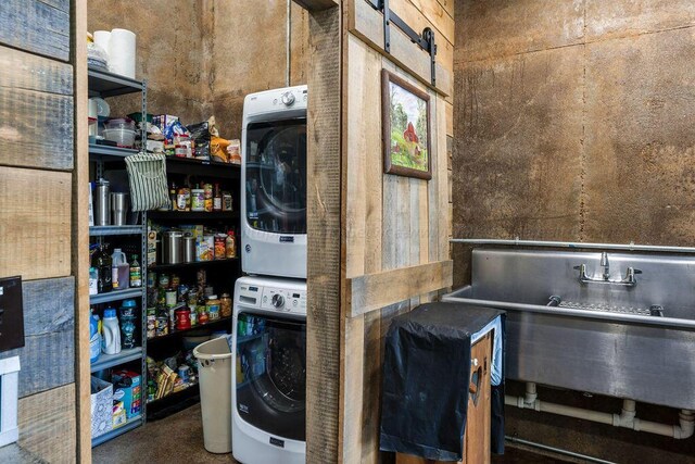 clothes washing area with stacked washer and dryer