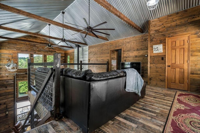 unfurnished living room with wood-type flooring, high vaulted ceiling, beam ceiling, and wood walls