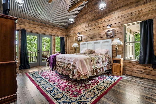 bedroom featuring multiple windows, wood walls, and hardwood / wood-style flooring