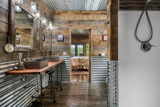 bathroom with wood walls, sink, and wood-type flooring