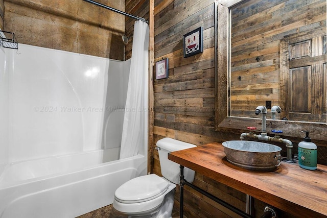 full bathroom featuring shower / bath combo, wood walls, toilet, and vanity