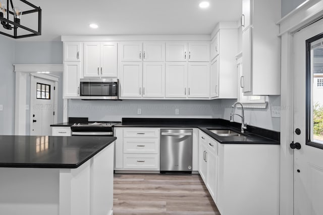 kitchen with sink, light hardwood / wood-style flooring, plenty of natural light, appliances with stainless steel finishes, and white cabinets