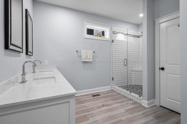 bathroom with vanity, hardwood / wood-style floors, and a shower with shower door