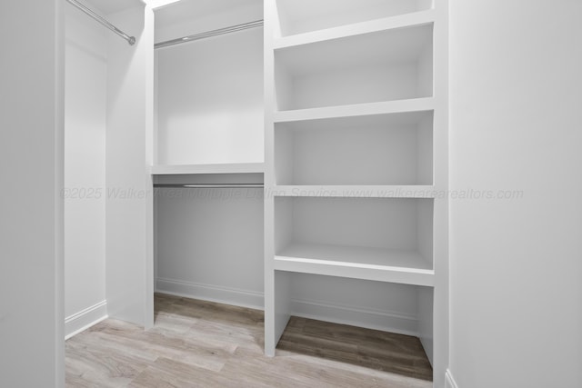 spacious closet with light hardwood / wood-style flooring