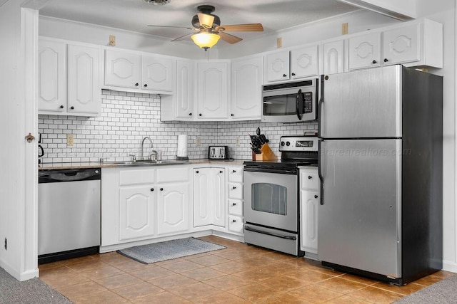 kitchen featuring white cabinets, appliances with stainless steel finishes, sink, and light tile patterned floors