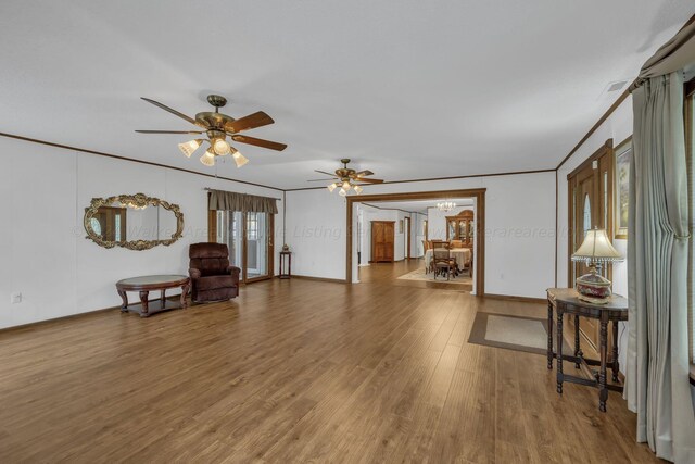 sitting room featuring hardwood / wood-style flooring, crown molding, and ceiling fan