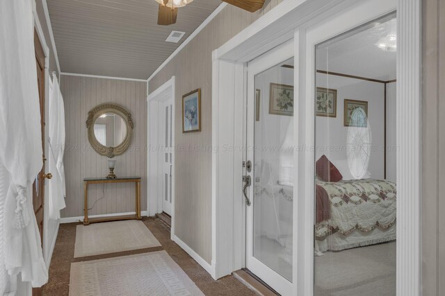 carpeted entrance foyer with crown molding and french doors