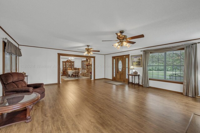 living room with ornamental molding, hardwood / wood-style floors, and ceiling fan