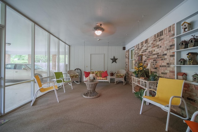 living area with carpet flooring, expansive windows, and ceiling fan