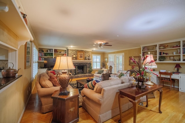 living room with crown molding, a fireplace, ceiling fan, and wood-type flooring