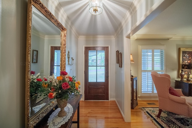 entryway with light wood-type flooring and crown molding