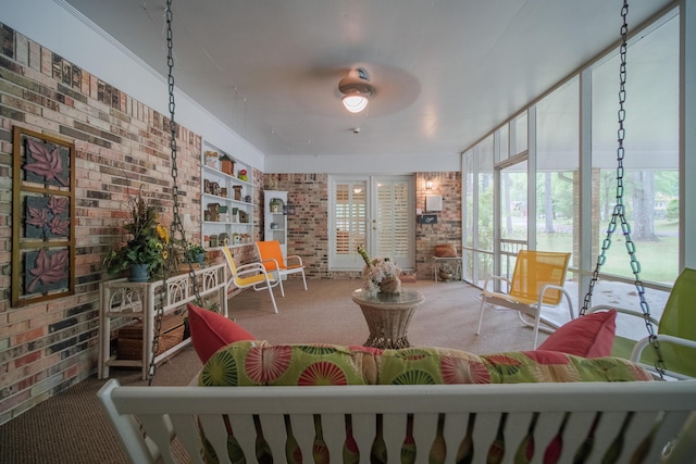 living room featuring carpet and brick wall