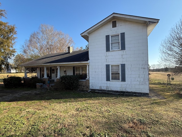 rear view of house with a porch and a lawn