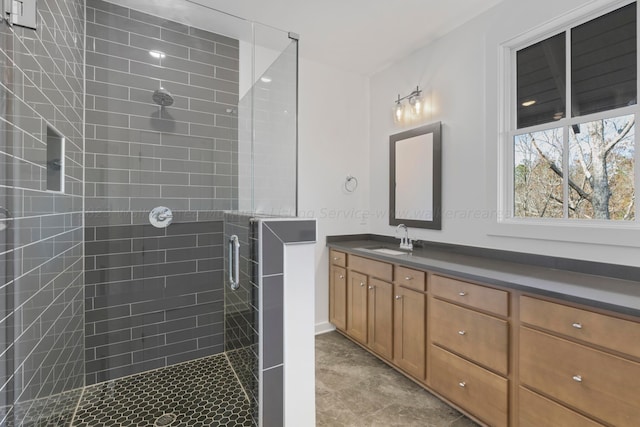 bathroom with a shower with door and vanity