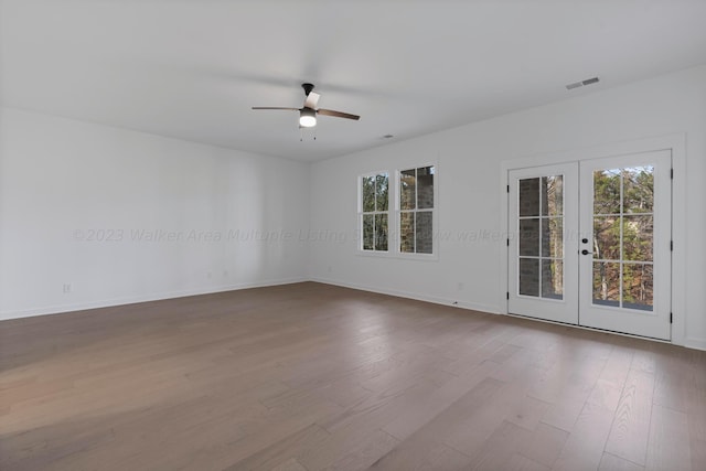 unfurnished room featuring french doors, ceiling fan, plenty of natural light, and hardwood / wood-style floors