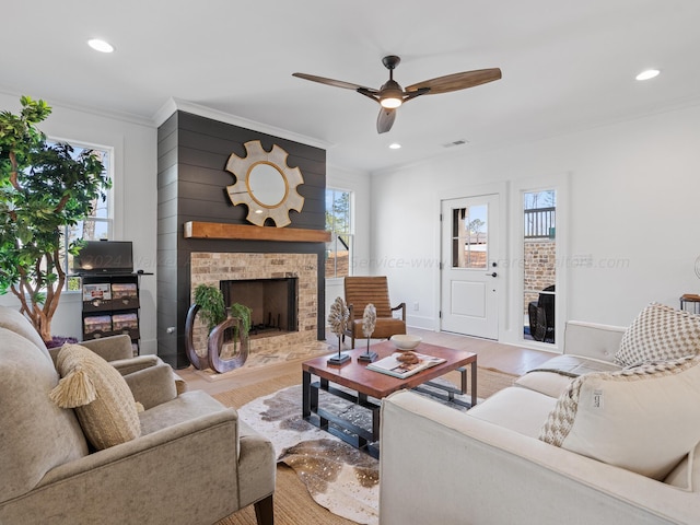 living room featuring light hardwood / wood-style floors, a brick fireplace, and a healthy amount of sunlight